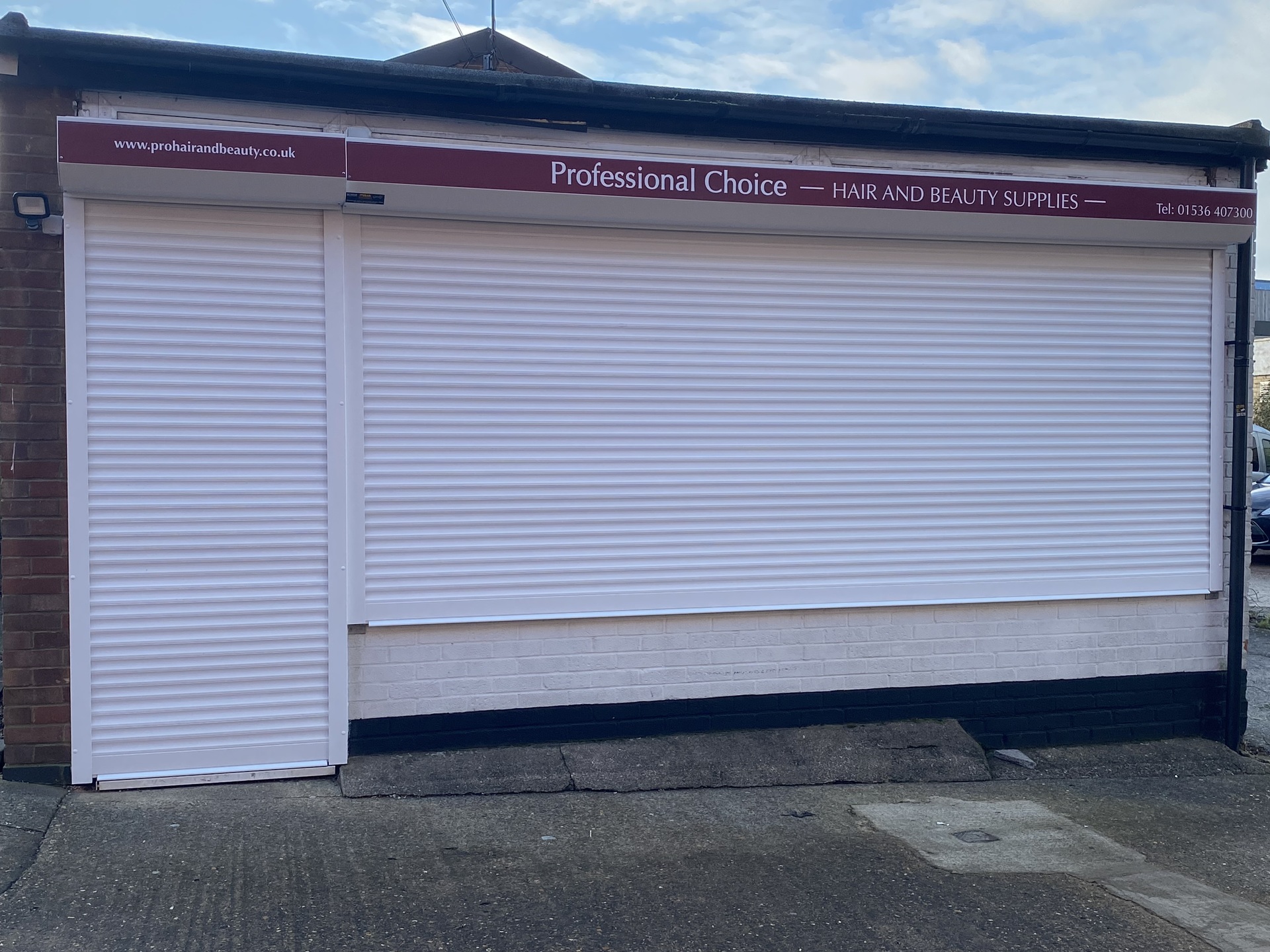External Security shutters covering shop window and entrance in white