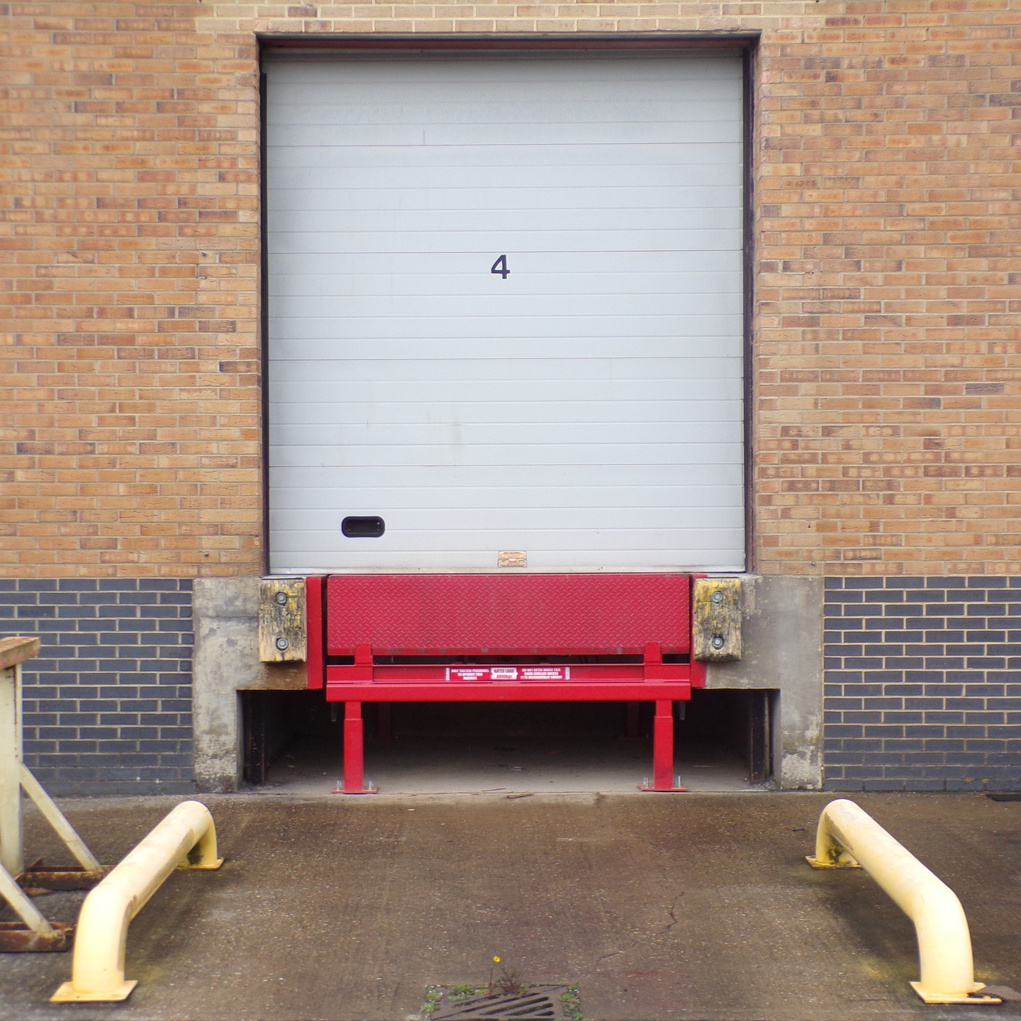 Hinged Lip Dock Leveller, external view, in red as installed by Stanair Industrial Doors Ltd