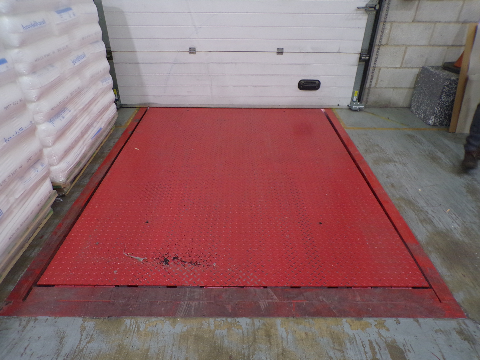 Closed hinged lip dock leveller in warehouse loading bay with toe guards and automated action