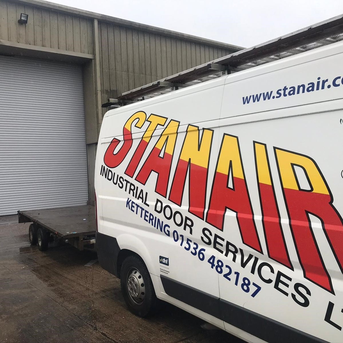 Stanair van with trailer outside of galvanised roller shutter door