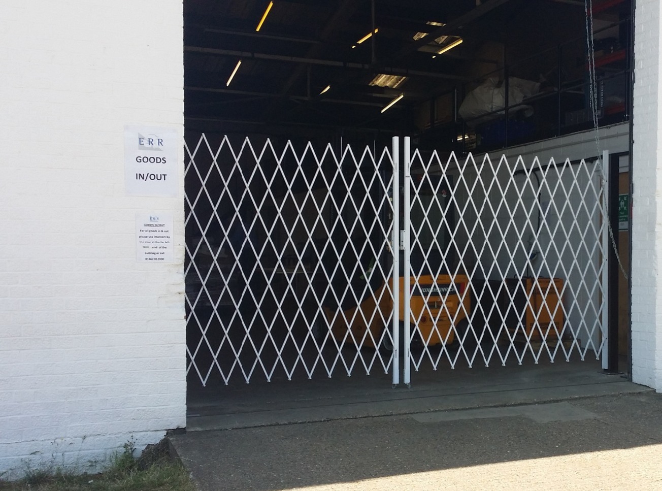 Sliding trackless gate across warehouse access point